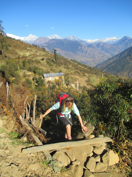 Sally climbing over a stile above Thulong Syaphru.